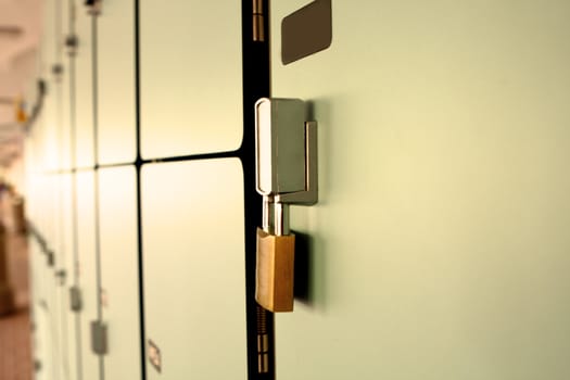Closeup view of a lock on a school locker with row of lockers .