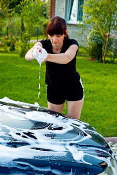 Adult cleaning her car outside