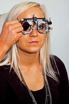 Young woman examining the eyesight in the optician's