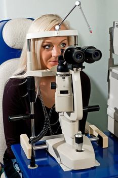 Young woman examining the eyesight in the optician's