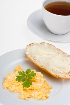 scrambled eggs and bun on a plate