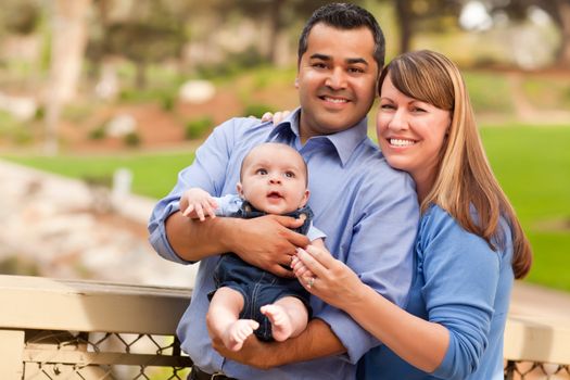 Happy Mixed Race Family Posing for A Portrait in the Park.