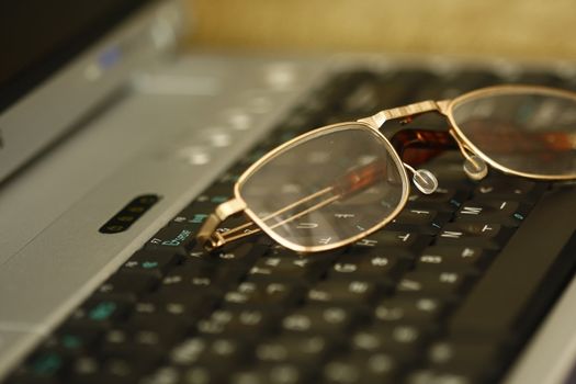 a businessmans glasses resting on his laptop