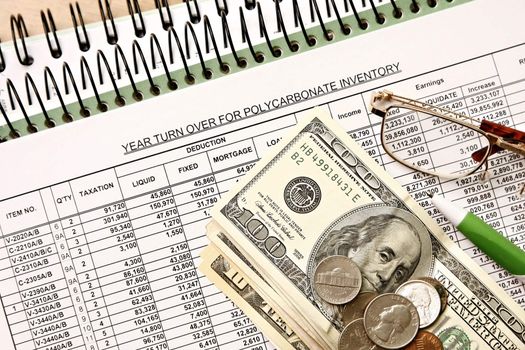 Spreadsheet with dollar financial figures and glasses