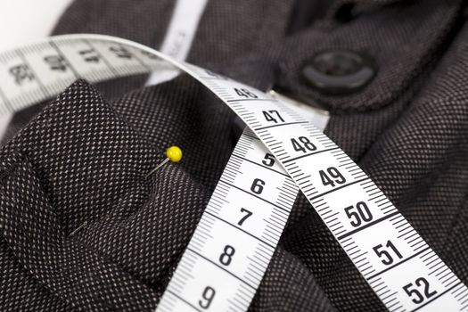 Measuring tape and trousers about to be altered.