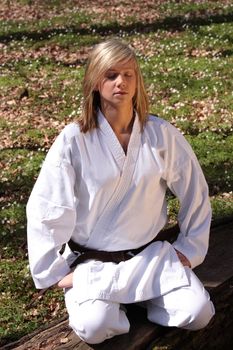 Karate girl meditating in nature