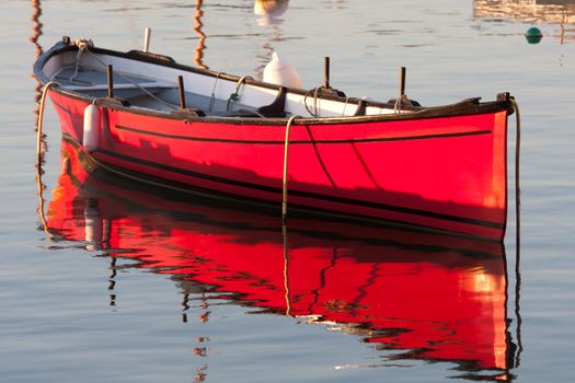 Morning light on a red boat at anchor