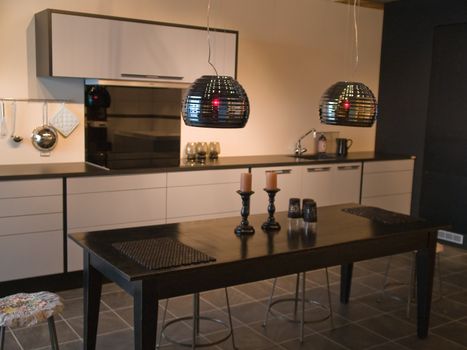 Modern design trendy kitchen with black and white wood elements, metal and glass