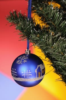 blue christmas-tree decoration on multicoloured background