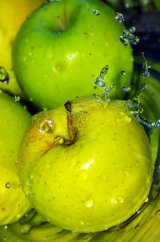 fresh water splash on green apple on metal background