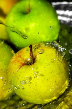 fresh water splash on green apple on metal background