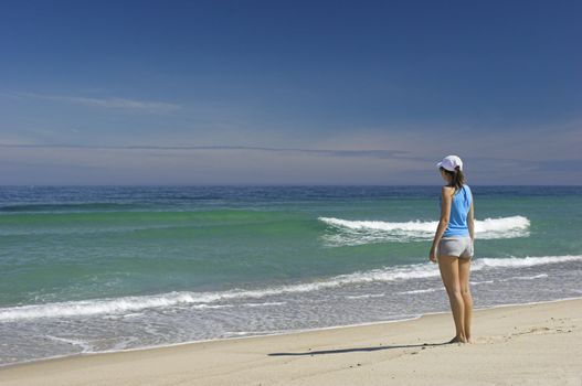 Beautiful woman walking on the beach feeling the breeze