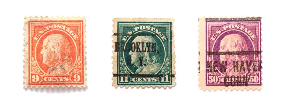 Three Benjamin Franklin US postal stamps in different values and colors.