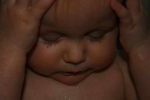 baby bathing and holding her head.