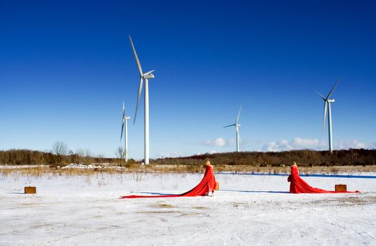 red ladies on snow field with windmills