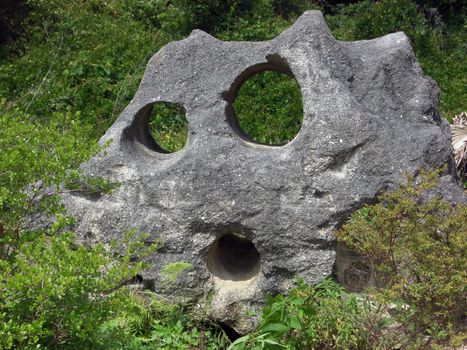 A large rock has an illustration of a  face inscribed in it.