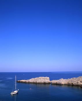 Sailboat moored off the coast of the village of Lindos on the greek island of Rhodes