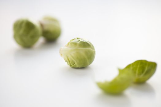 Fresh brussel sprouts with shallow depth of field isolated on white background.