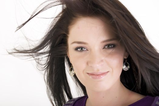 Portrait of a young beautiful brunette with the hair blowing about