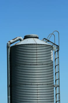 A Metal feed silo against blue sky