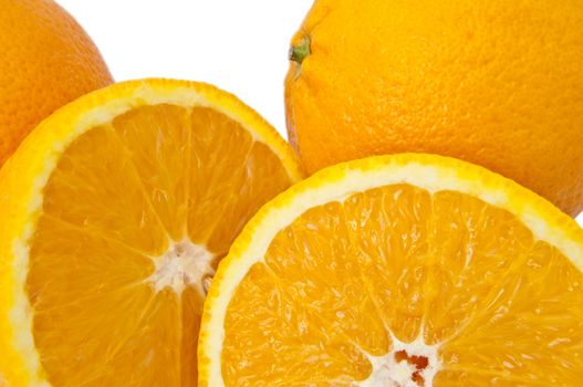 Close up of whole and cut oranges arranged over white.