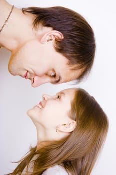 The man looks down on the girl on a white background