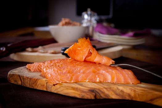 Plate of fresh smoked salmon with other fish in the background