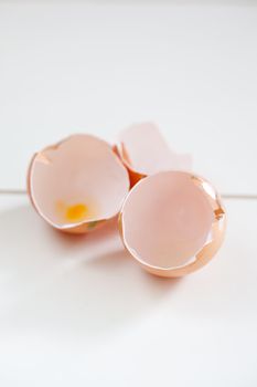 Three empty egg shells lying on a table surface