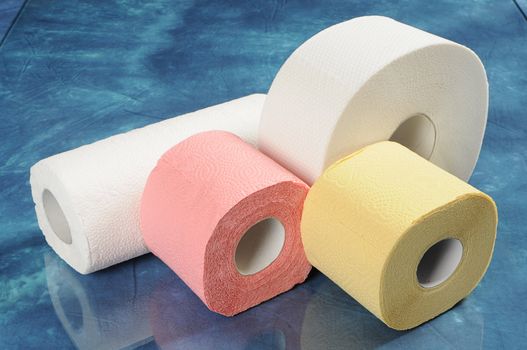 A set of rolls of toilet paper and paper towels with reflection