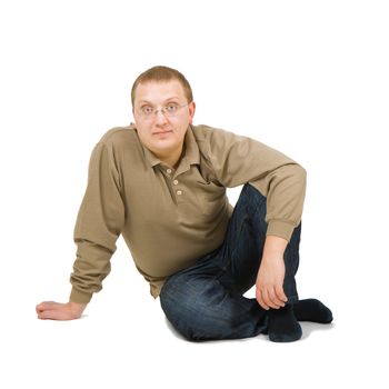 calm young man sits on a white background
