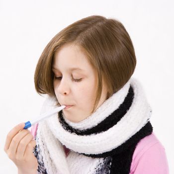 Teen girl wearing a scarf with a thermometer in her mouth
