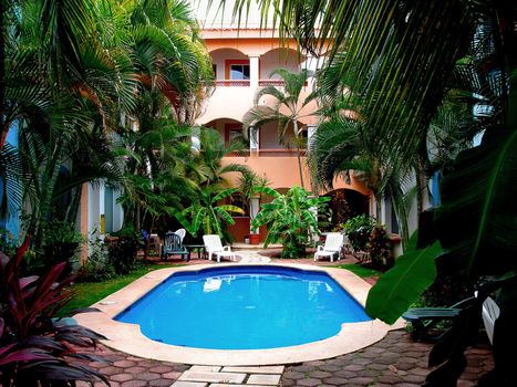 Courtyard of tropical condos with superb blue water pool, inviting destination.