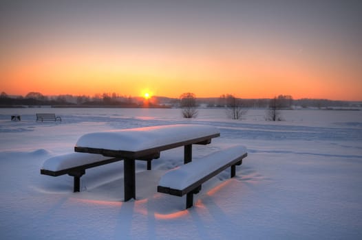 Beautiful winter sunset with a table and benches