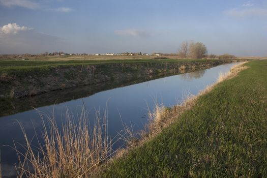 irrigation channel in eastern Colorado farmland, full of water, early spring