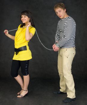 Lady guide shackled young man on the black