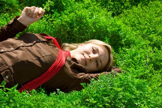 Blond girl relaxing on sun in green grass