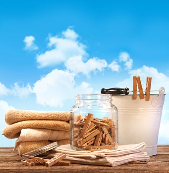 Laundry day with towels, clothespins on table against blue sky