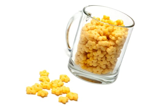 Glass cup full dry morning meal, disposit flakes on white background