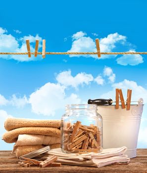 Laundry day with towels, clothespins on table against blue sky