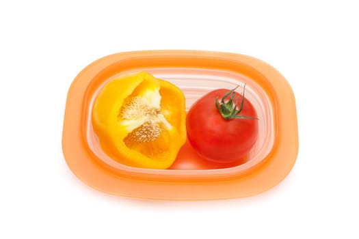 Cut wanted pepper and red tomato in orange plastic container insulated on white background