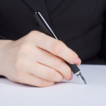 Female hand holding a fountain pen with a silver pen