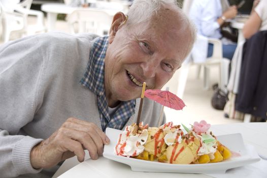 Old senior man enjoying his sweet ice cream sundae