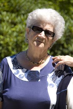 Old senior woman with sunglasses on a sunny day