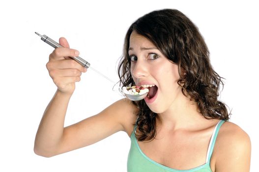 Pretty young woman holding spoon with pile of pills looking skeptical. Concept shot for drug abuse or pharmaceutical industries.