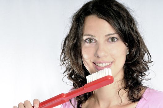 Smiling girl with big toothbrush isolated on white background