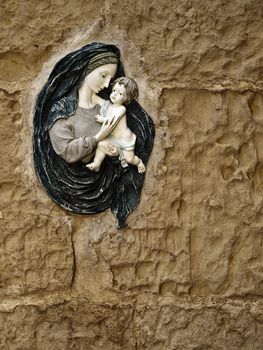 An icon of Madonna and baby Jesus on a limestone eroded wall in Malta