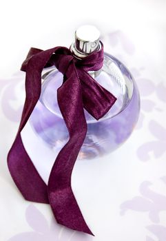 Violet bottle of perfum with silky ribbon