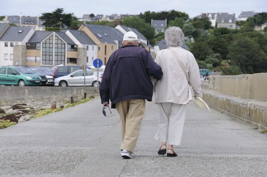 Old senior couple walking together holding their hands