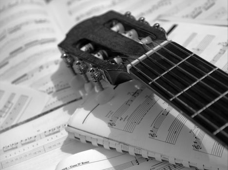 Head and neck of an acoustic guitar with sheet music