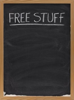 free stuff text handwritten with white chalk on blackboard, copy space below, eraser smudges